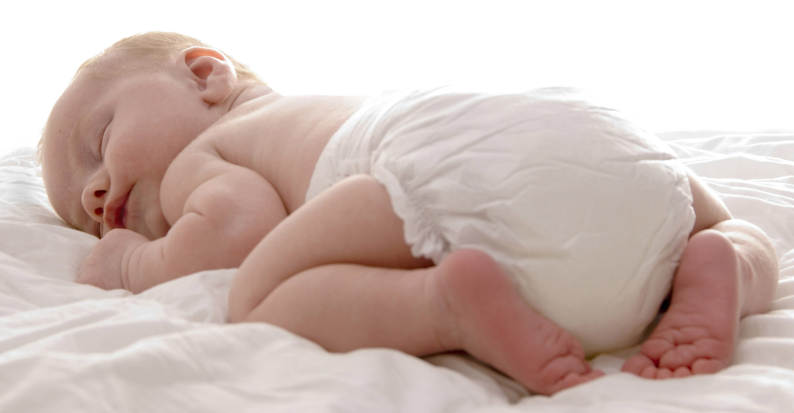 Почему новорожденный лежит. Ребенок в подгузнике. Новорожденный лежит на животе.